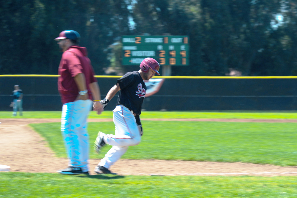 Catcher Ro Mahanty high-fives third base coach Brian “Boomer” Richer as he rounds the bases following his home run in a 9-7 victory against Skyline College on April 20, at Baylands field.