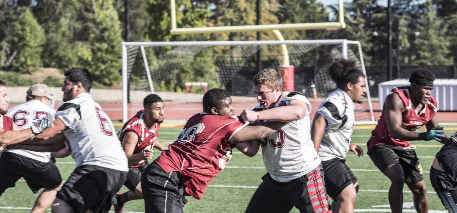 Top: Members of the De Anza College football team run a drill in which they practice their offense and defense on running plays at a spring practice on May 18. In the spring sessions the Dons focused on weight lifting and film study, as well as two hours of on the field practice three days a week.
Only returning players are participating in the spring practice. The incoming freshmen will begin in July.
When the incoming players join the practices, the coaches will start teaching from the beginning, said assistant coach and offensive coordinator Burt Codera.