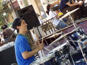 Coree Hogan laughs and plays drums as he stares at Michael Conour, making sure he keeps in time.