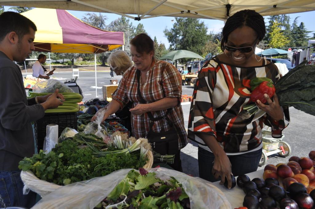 De Anza College student trustee Thomasina Russaw (right) shops for local fruits and vegetables at De Anza Colleges farmers market on Oct. 2