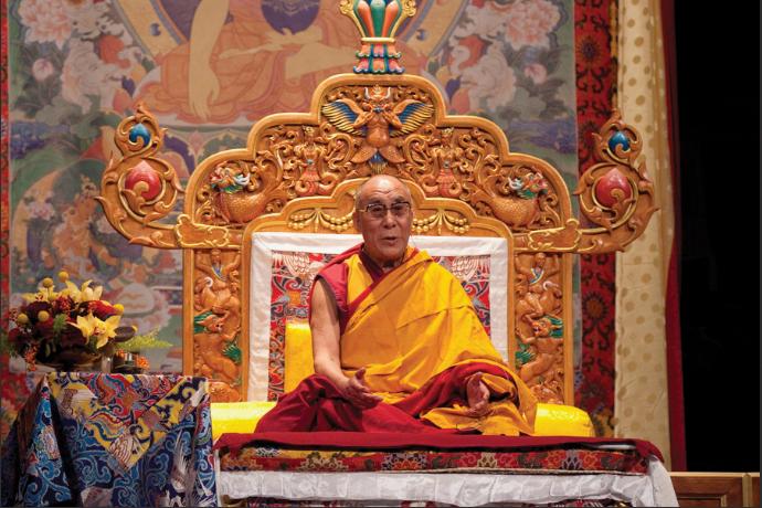 His Holiness the Dalai Lama sits on his throne to tach compassion and self-awareness. The Dalai Lama says a calm mind maintains health and judgment and enables people to utilize true human inteligence.