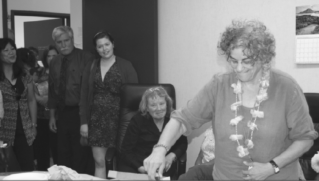 FESTIVITIES FOR THE HONORED - Beth Grobman, former adviser to La Voz Weekly, cuts the cake at festivities with colleagues and friends Thursday in the Language Arts Division Office.  Grobman retires after 24 years of service at De Anza College.