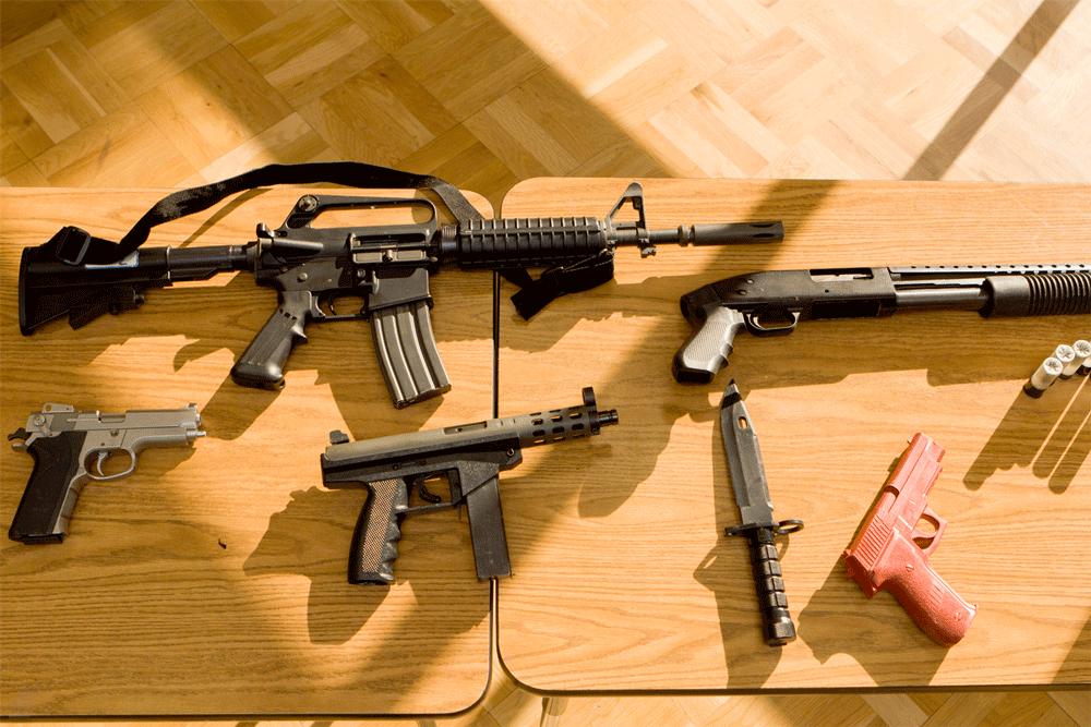 WEAPONS - From top left, clockwise, assault rifles, shotgun, training pistol, knife , machine pistol, and pistol. All these weapons are displayed at a safety demonstration for staff and faculty.