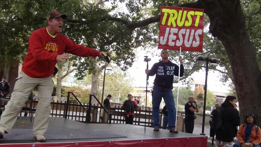 SPEWING HATE - A religious advocate brandishes a Bible and rants at passersby,  condemning De Anza students’ faiths and lifestyles in main quad. He railed against a student dressed in black, sodomy, and lesbians and other provocations Oct. 11.