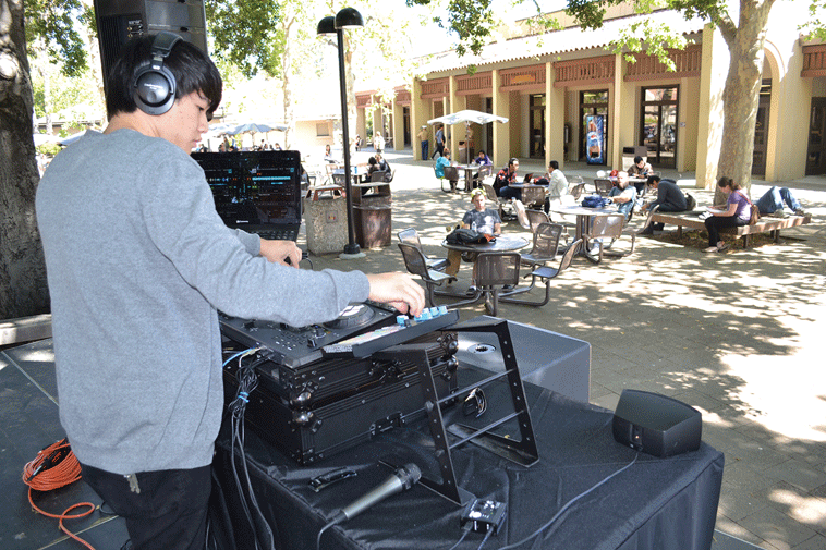 Ma, aka DJ Vicadin, makes adjustments while his music transitions from one song to another in the main quad.