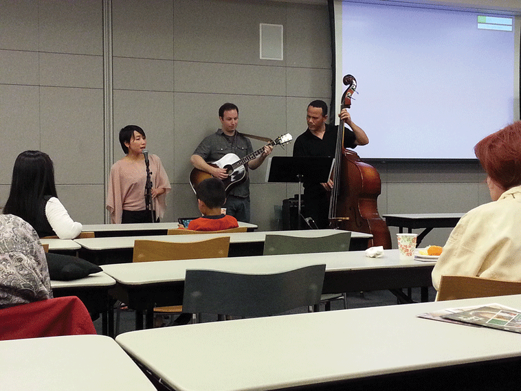 Vocalist Thuy Linh, guitarist Eric Salueson and bassist Paul Collins perform jazz during the opening ceremony of a human trafficking photo exhibit at the Dr. Martin Luther King Library in San Jose, Sunday, April 14.
