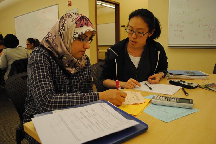 <p><b>Crunching Numbers</p></b>
Student employee Jessica Xu, 20, biology, guides Mona Hadi, 28, nursing, through her math homework at the Math and Science tutoring center.