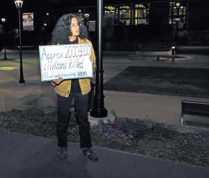 Students for Justice club member Steven Alvarado holds up a sign detailing the number of civilian drone strike
casualties in protest of former Secretary of Defense Leon Panetta, who spoke at the Flint Center at De Anza College, Feb. 20.