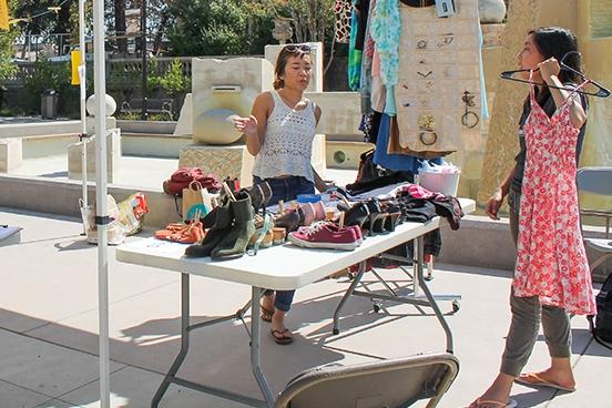 Volunteers and members of the jean Miller Resource Room offer shoes, clothes and accessories for trade at a clothing swap in the Sunken garden on Tuesday, Oct.7.