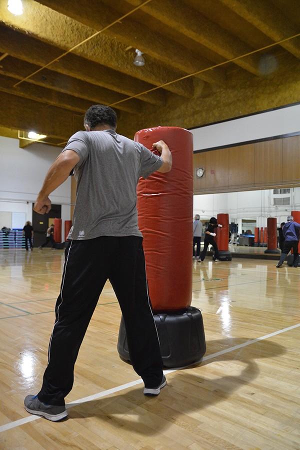 A De Anza student takes jabs at a punching bag during a cardio drill.