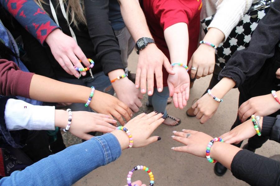 Participants in a “Globalizing Sisterhood” workshop show off the bracelets they made and traded with each other. The workshop was part of a LEAD’s Global Issues Conference on Thursday, March 3 at De Anza College.