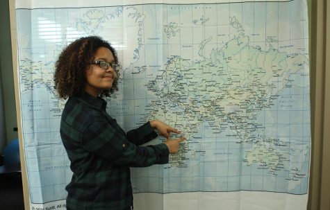 Bemesgana Alemu, 19, chemistry major, points to her home-town of Addis Ababa, capital of Ethiopia, on the world map. The map’s caption reads: “The world is a book and those who do not travel read only one page.”
