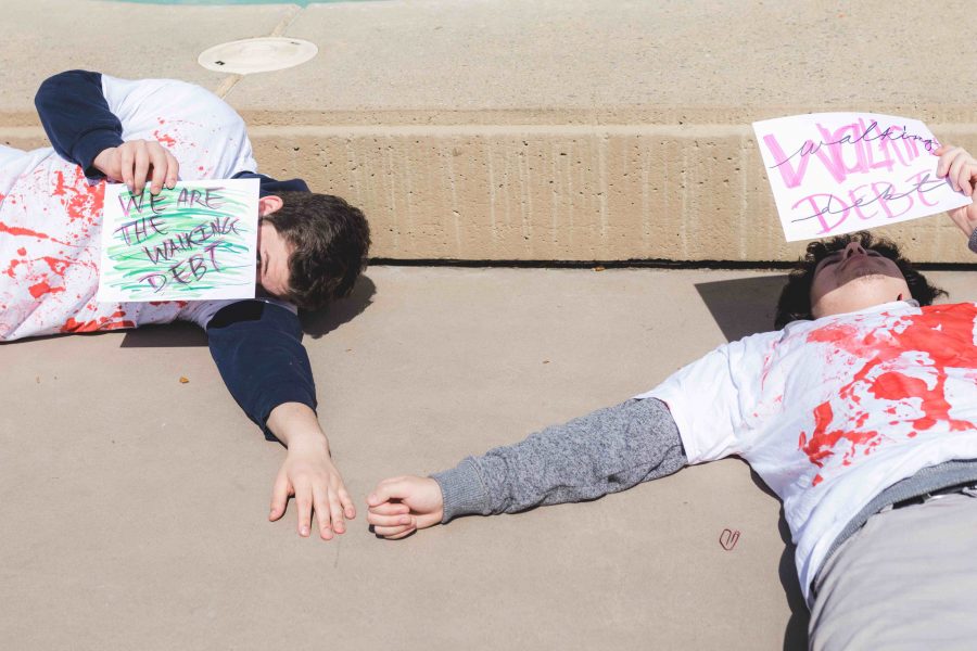 Students lie on the quad holding up signs to protest the 5% CSU tuition increase.