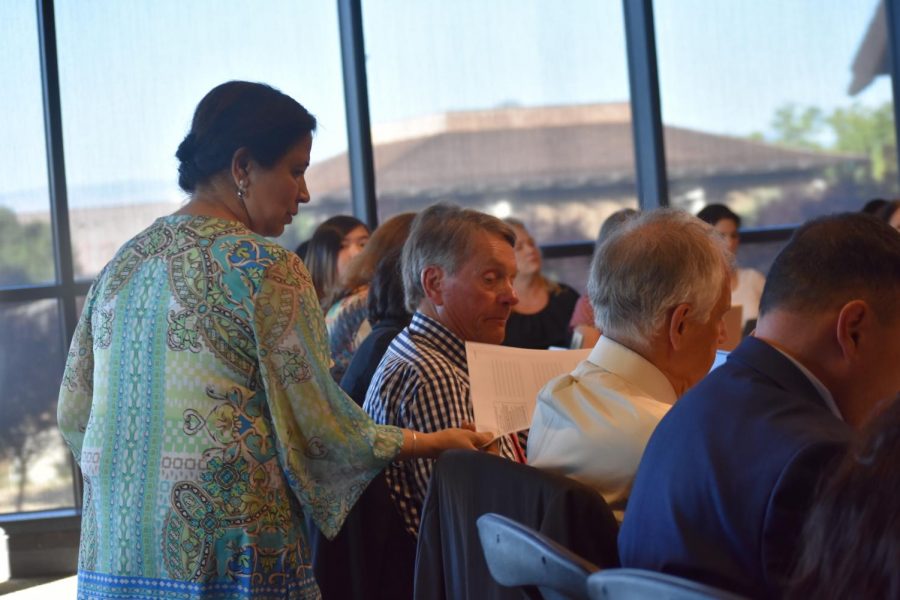 De Anza professor Ravjeet Singh hands out proposals to solve the enrollment crisis during the Foothill-De Anza Board of Trustees’ meeting June 11.