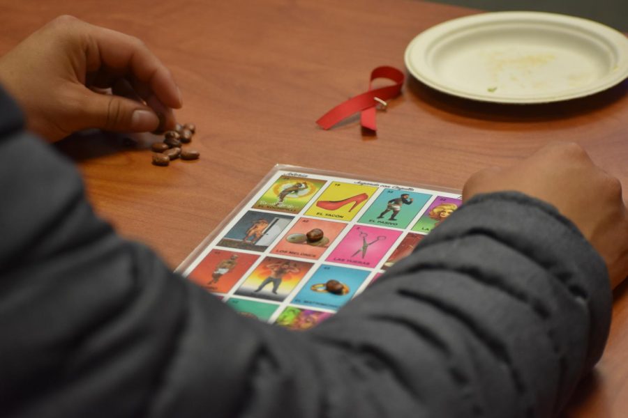 Aldo Martinez, 23, art major, plays the game Joteria, and LGBTQ+ version of Loteria during the event.