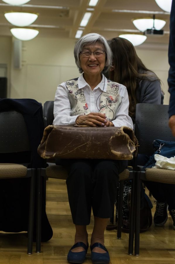 Amy Iwasaki Mass holding one of the 50 objects, the Bag by the door at the Day of Remembrance event on Feb. 19.