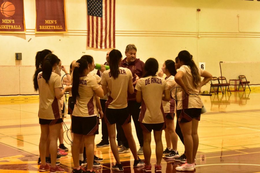 Womens badminton head coach Mark Landefeld talks with team.