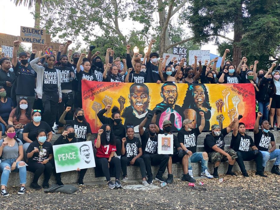 Black Lives Matter protesters raise their fists in solidarity with the movement June 9 in San Jose, and raise a poster with the faces of Breonna Taylor, George Floyd and Armand Abhari.