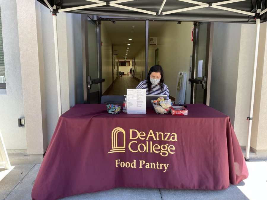 Staff at De Anza's food pantry wears a mask while working as per district policy.