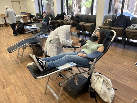 Isabel Nelson, 21, psychology major, overcomes her fear of needles with Page Cal Ortiz, a Stanford registered nurse by her side.