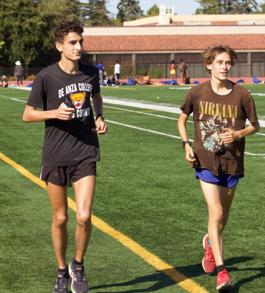 Student athletes Antoine Moret (left) and Elliot Daniels (right) are running a cool-down lap after running four miles at the track stadium on Monday, Oct. 23.
