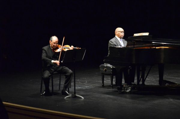 From left, Joseph Gold, violinist, and Carl Blake, pianist, play their instruments on stage for students, faculty and donors.