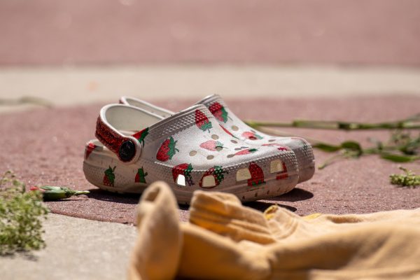 A pair of white childrens crocs emblazoned with strawberries sit empty, surrounded by other items of clothing and flowers in the memorial in Palo Alto on April 21.
