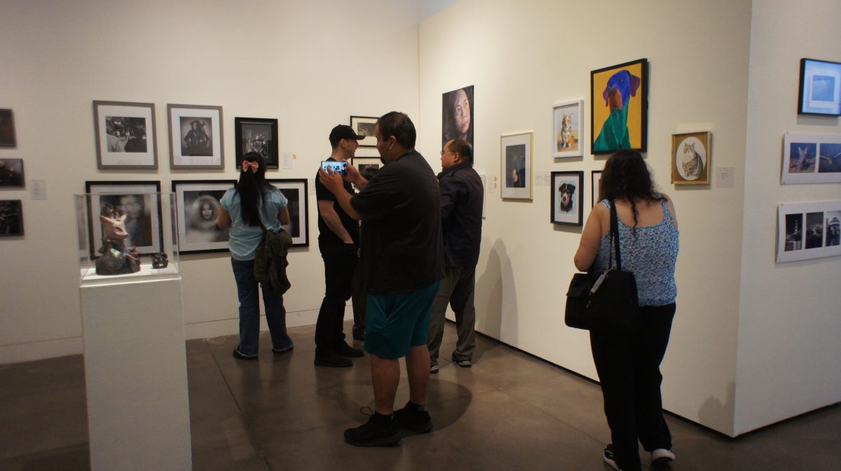Reception+attendees+browse+the+exhibit+at+the+Euphrat+Museum+of+Art+on+May+15.