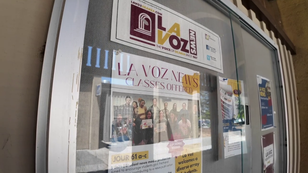 Poster board showing La Voz advertisements taken outside of the La Voz classroom.