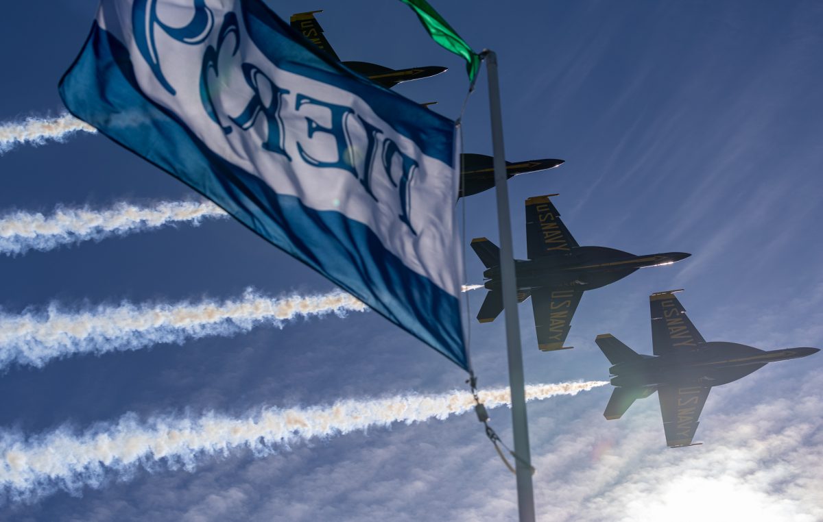 The U.S. Navy Blue Angels F/A-18 Super Hornets fly behind the Pier 39 flag in echelon formation during a low flyover of the pier in San Francisco on Oct. 11.