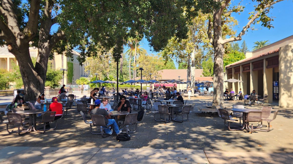 Students hang out in the shade provided by the oak trees outside of the Campus Center, on Wednesday Oct. 2 at De Anza College.