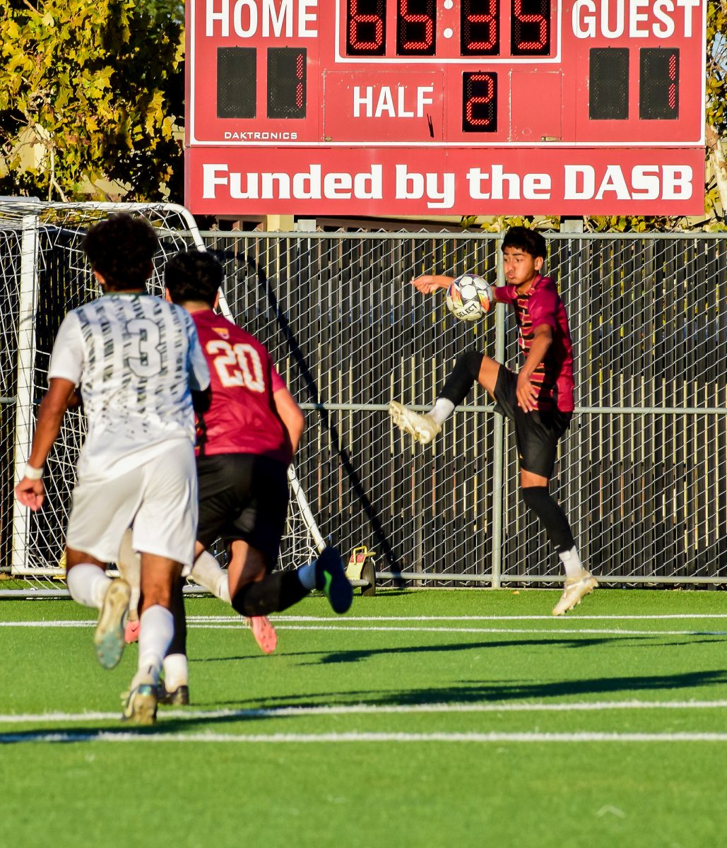 Forward Andre Gonzales (De Anza No. 7), a business major, controls the ball onto the ground before assisting his teammate, forward Peewee Orocio (De Anza No. 20), 17, a business management major, for a goal on Oct .18.