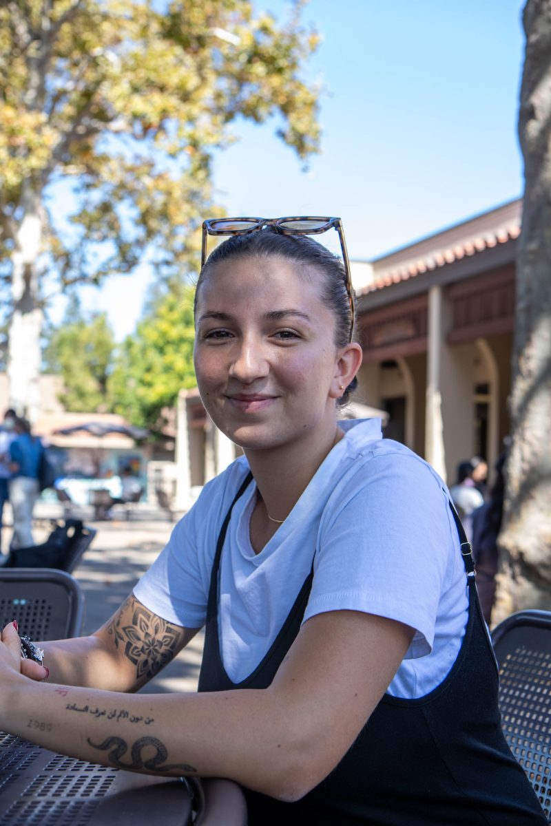 Virginia Fibanzi, 22, an international student studying biology, sits at a table outside the Hinson Campus Center.