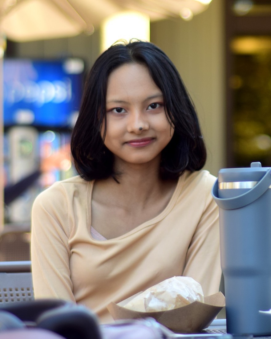 Waingnadi Win, 16, a system programming major, sits in the plaza outside the Hinson Campus Center.