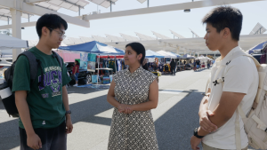 Xitlaly Martinez, La Voz reporter, speaks to students Yan and Leo at the flea market on Oct. 5.