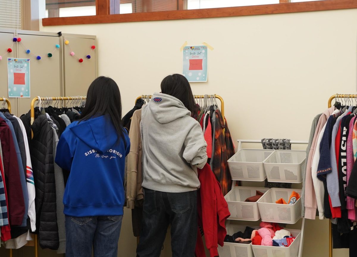 Students look at free jackets at the Winter Coat Drive located in Registration and Student Services Building on Nov. 21. Students are only allowed to pick one item per section.