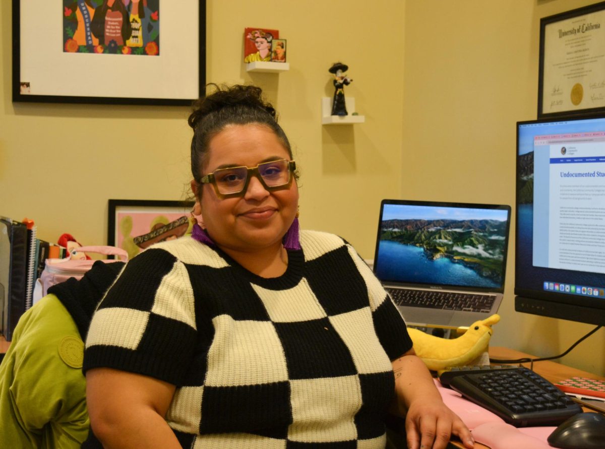 Higher Education for AB 540 Students Program Coordinator Shaila Ramos-Garcia at her office desk located in the HEFAS center, as she greets students and other visitors on Dec. 5.