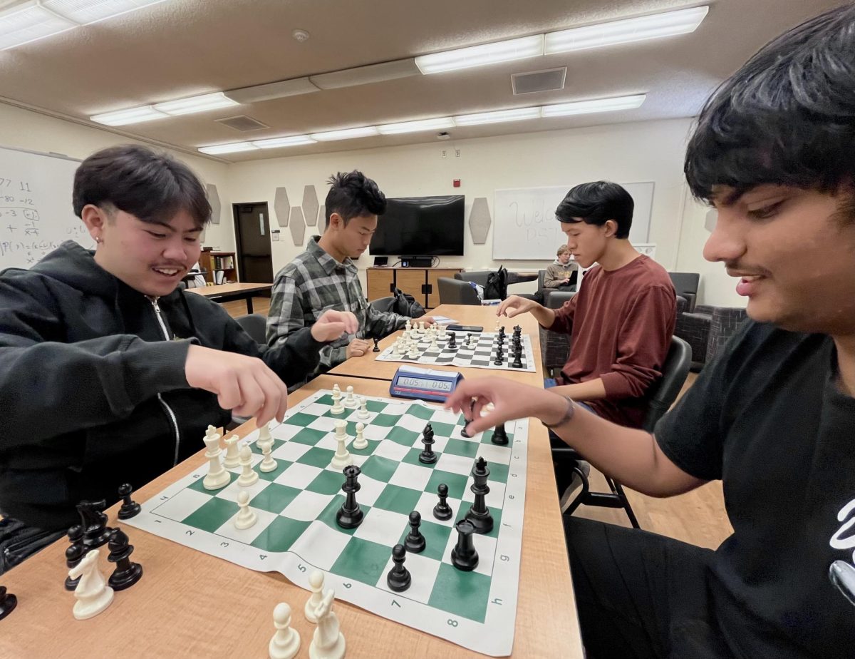 From left, Daniel Flores, 18 economics major, Eric Liu, 17, computer engineering major, Suparm Posina, 19, data science major, and Ben Hung, 18, computer science and engineering major play chess in the Physical Sciences and Technology Village on Oct. 31. Flores and Posina try to beat the clock in a one minute match, while Liu and Hung face off.