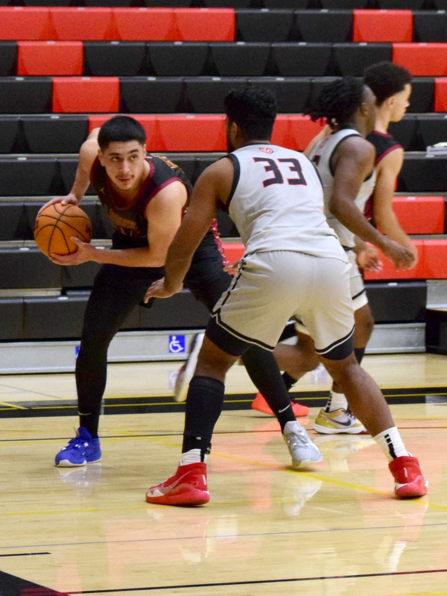 Forward Sean Crowley (De Anza No. 32), 20, business administration major, keeps the ball away from guard Milandev Chatha (Skyline No. 33) in the Skyline College Gymnasium on Jan. 8.