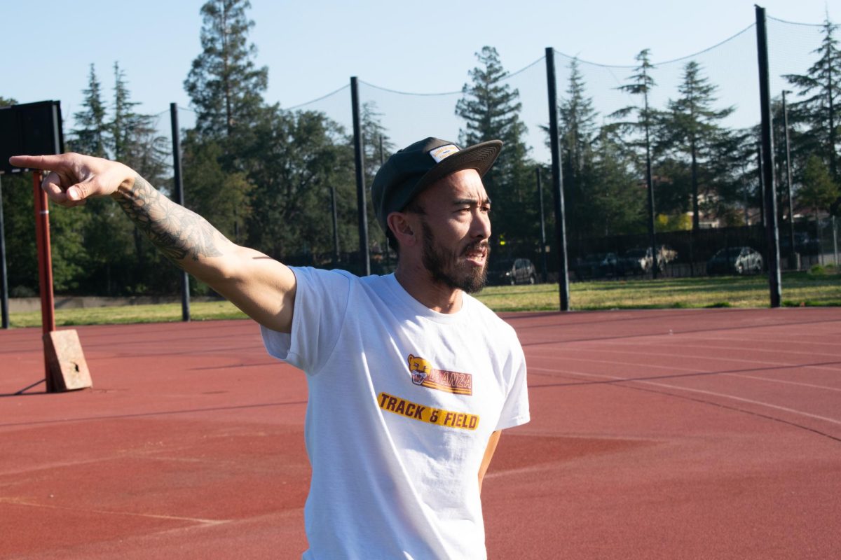 Sean Gwi, head coach of track and field, explains the structure of practice for the day at the football field on Jan. 30.