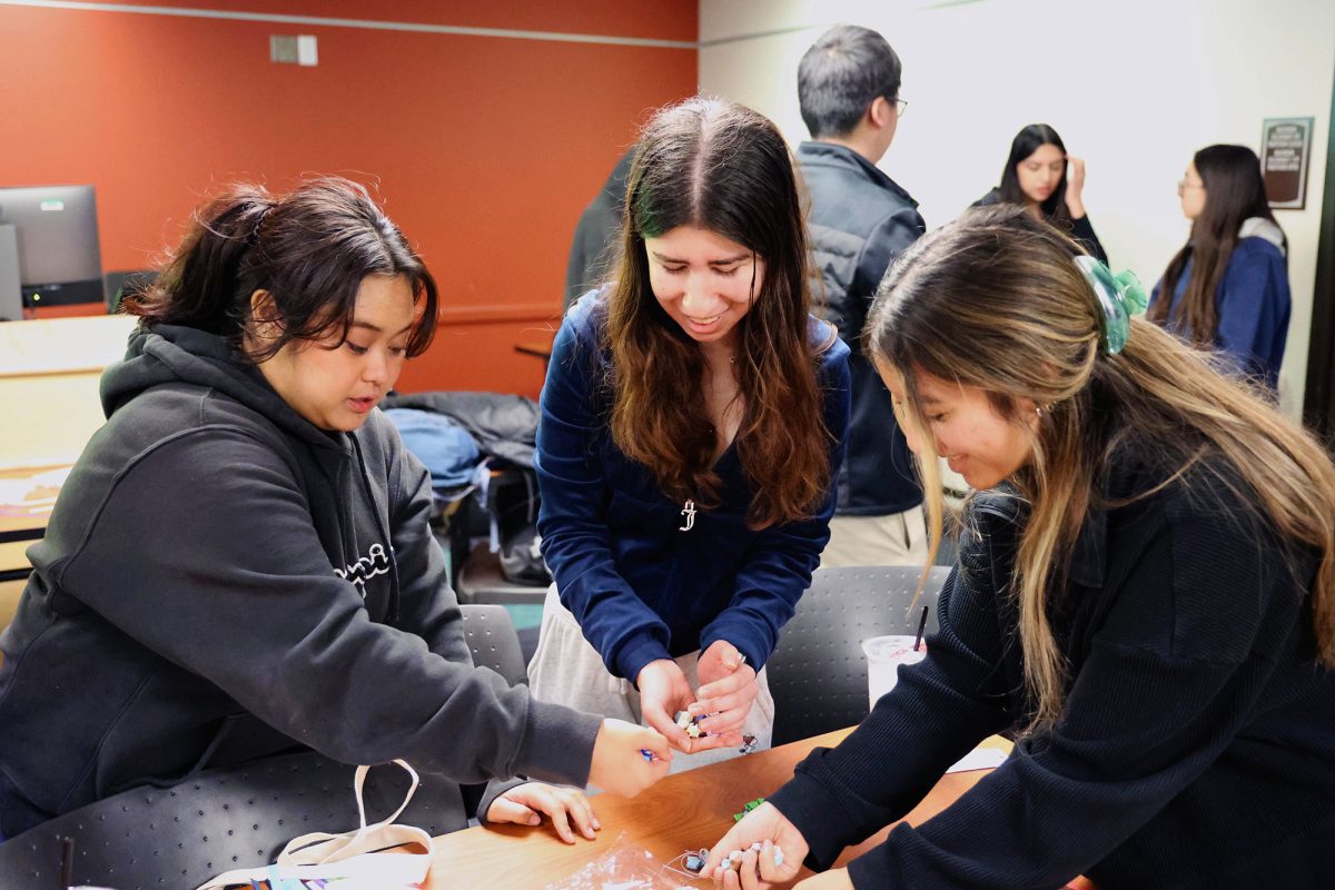 From left, Jaimee Rose Andaya, 19, Maayan Pendler, 19, and Nancy Juarez, 19, collect paper stars on Feb. 5 at the Student Council Chambers. Students help pack up as the event comes to a close.