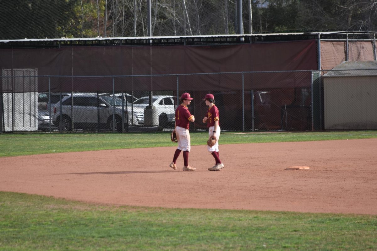 Luca Calderone (left) and Drew Paxton (right) bump elbows during the home game against Diablo Valley at the De Anza College Baseball Field on Feb. 18.