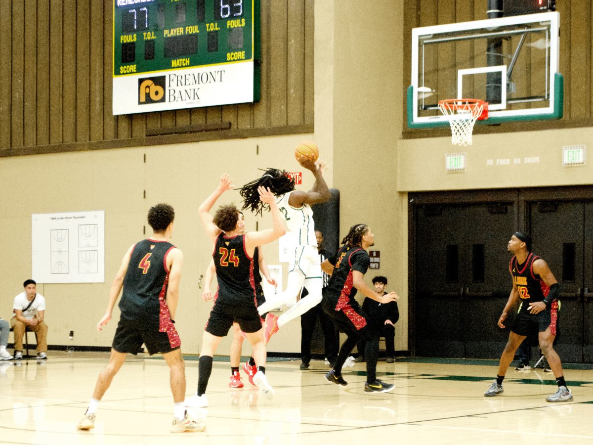 Anthony Lacy (Ohlone No. 12) attempts  a layup while Theo McDowell, 18, business marketing major (De Anza No. 24), blocks in the Epler Gymnasium at Ohlone College on Feb. 21. 