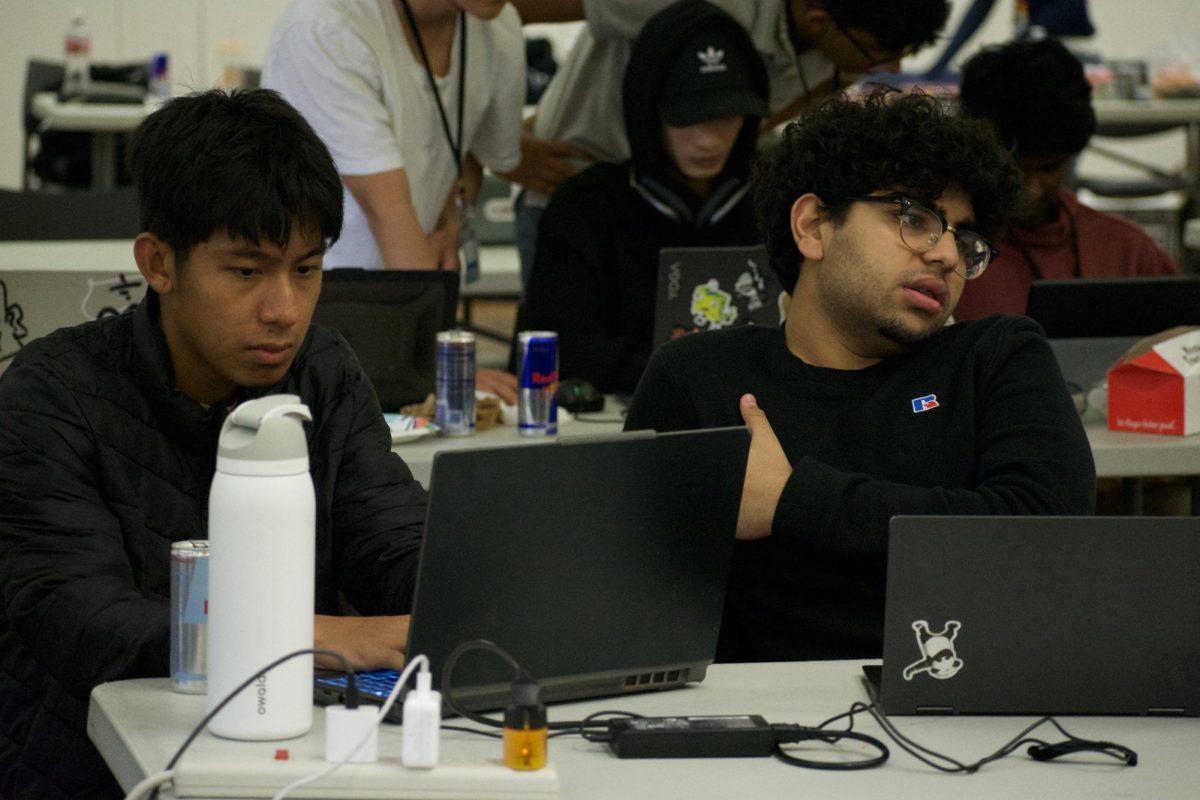 From left, KoKo Thant, 20 electrical engineering major, and Raed Shaikh, 18, computer science major, work together with the rest of their team to create a chatbot targeted for De Anza transfer students. The bot gathers information on majors and colleges, calculating the likelihood of student's acceptance and creating roadmaps their college admission.