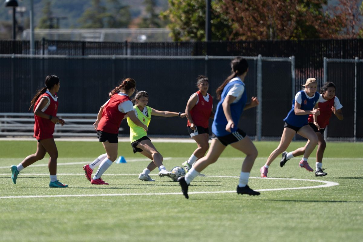 Women’s soccer players run positional drills during practice Oct. 6, at the De Anza College soccer field.