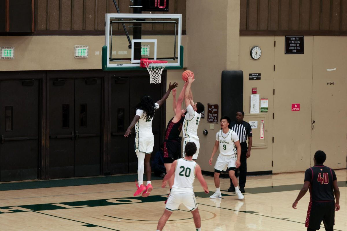 Guard-forward Theo McDowell (De Anza No. 24), 19, business major, fights for the rebound over center Kiratraj Sanghera (Ohlone No.5) in the final 3 minutes of the game.