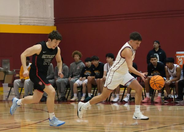 Guard Gio Brovelli (De Anza No. 12), 19, business administration major, rushes to the Trojans' side of the court with guard Osha Moloney (Skyline No. 24) hot on his tail in the De Anza College Main Gym on Feb. 20.