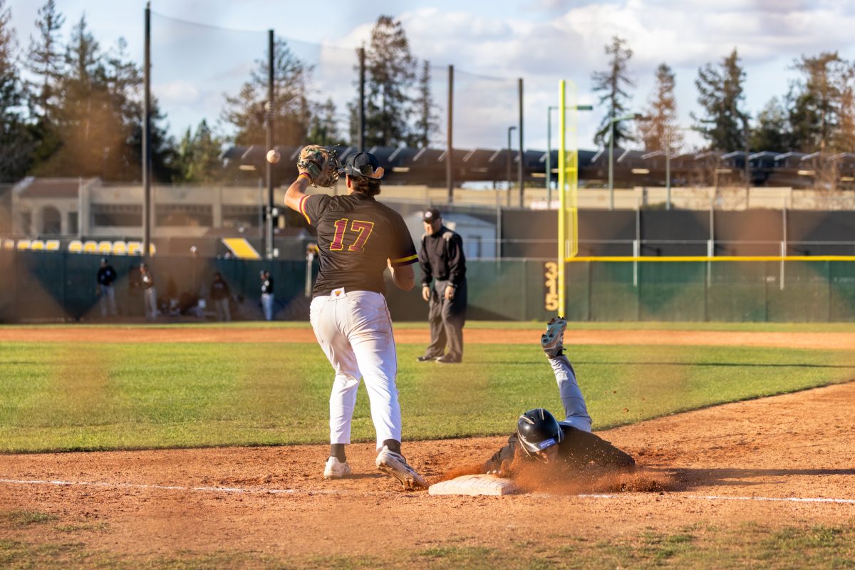 Infielder Keanu Hennings (De Anza No. 17) reaches for the ball while Josh Ybara (Cabrillo No. 38) slides back to first base after attempting to steal second base during the home game vs Cabrillo on Feb. 21.