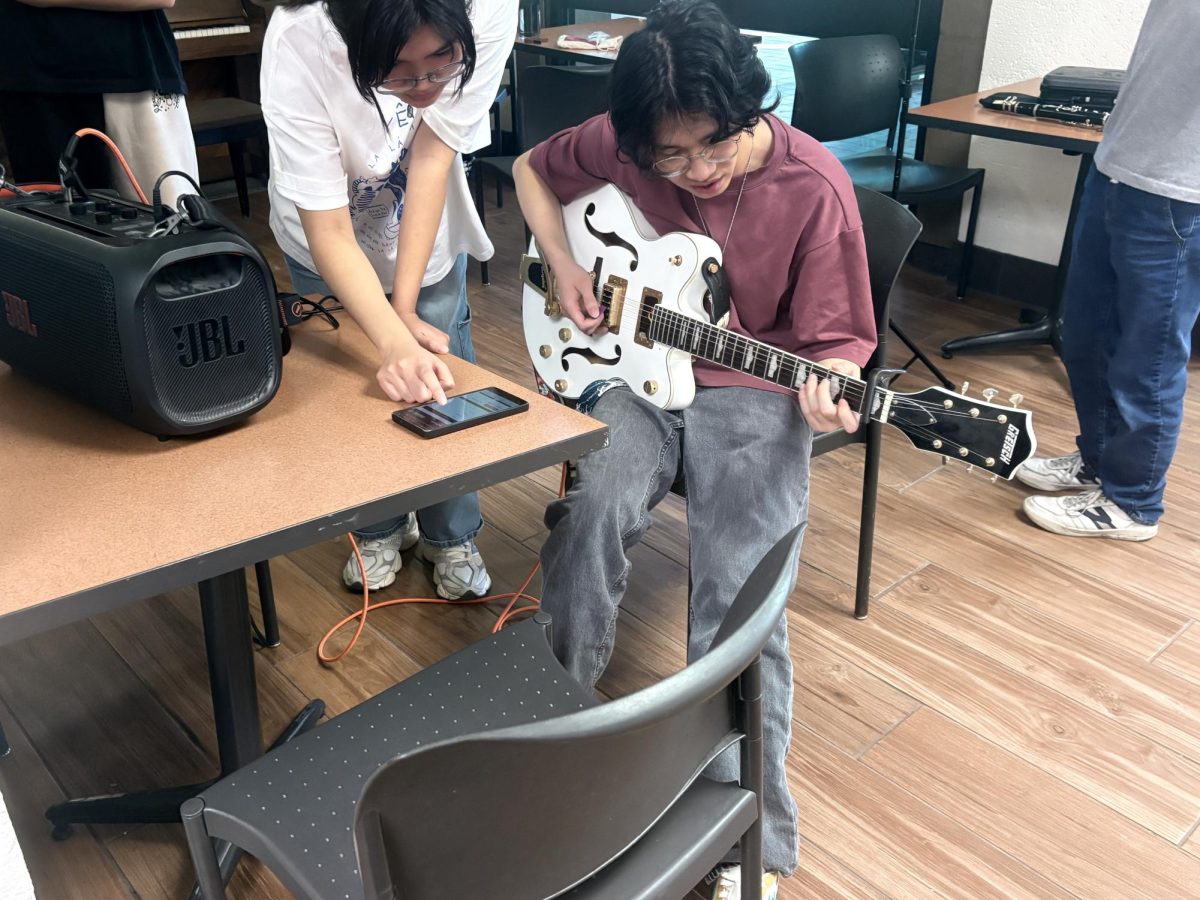 Huey Lee, 21, computer science and political science major, warms up with his Gretsch Hollow body electric guitar. The guitar gives a warmer sound than a typical electric