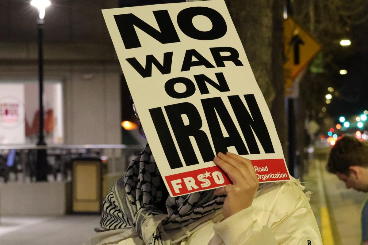 A protester conceals their face with a sign against the United States' involvement with Iran during the protest at Martin Luther King Jr. Library on March 3.